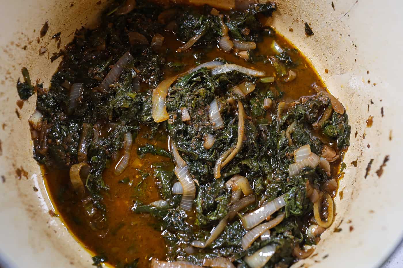 mustard greens and onions in a blue pot