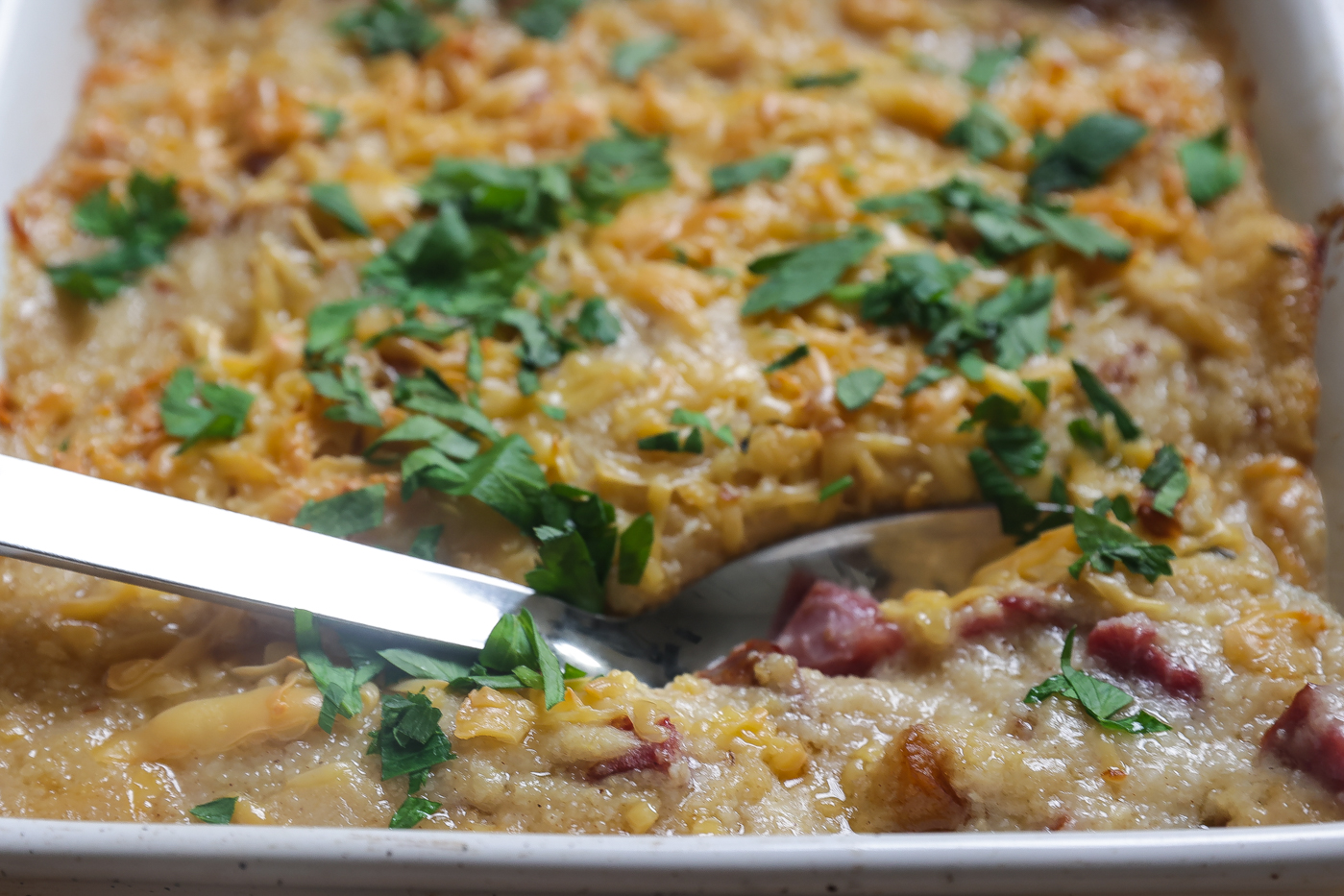 baked grits with cheese in white pan