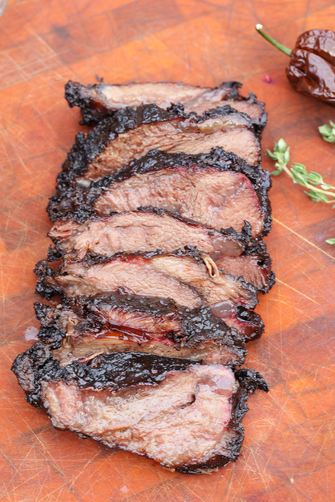 smoked beef cheeks sliced on a wooden cutting board