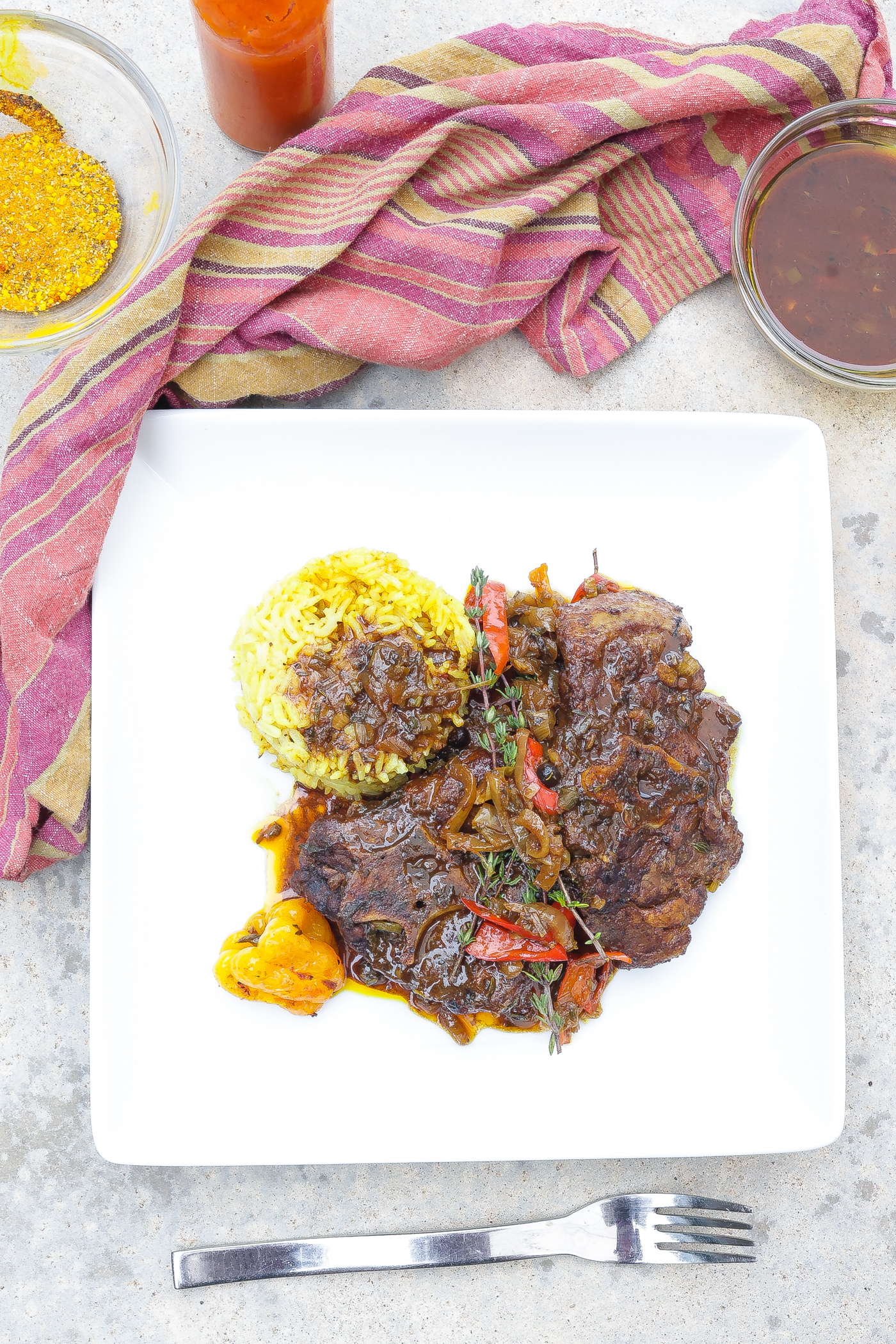 brown stew lamb necks with rice on white plate