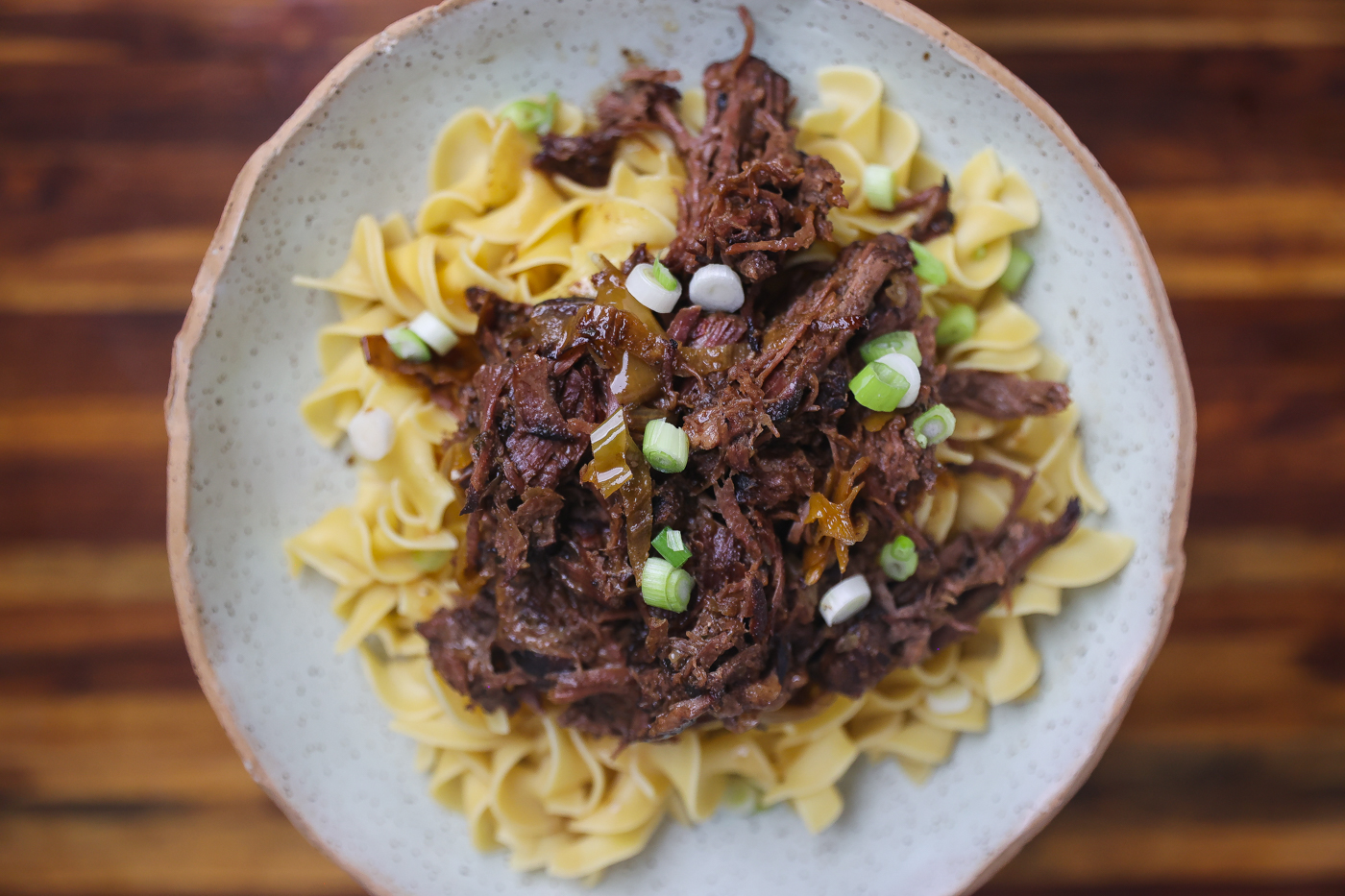 mississippi pot roast shredded on top of egg noodles