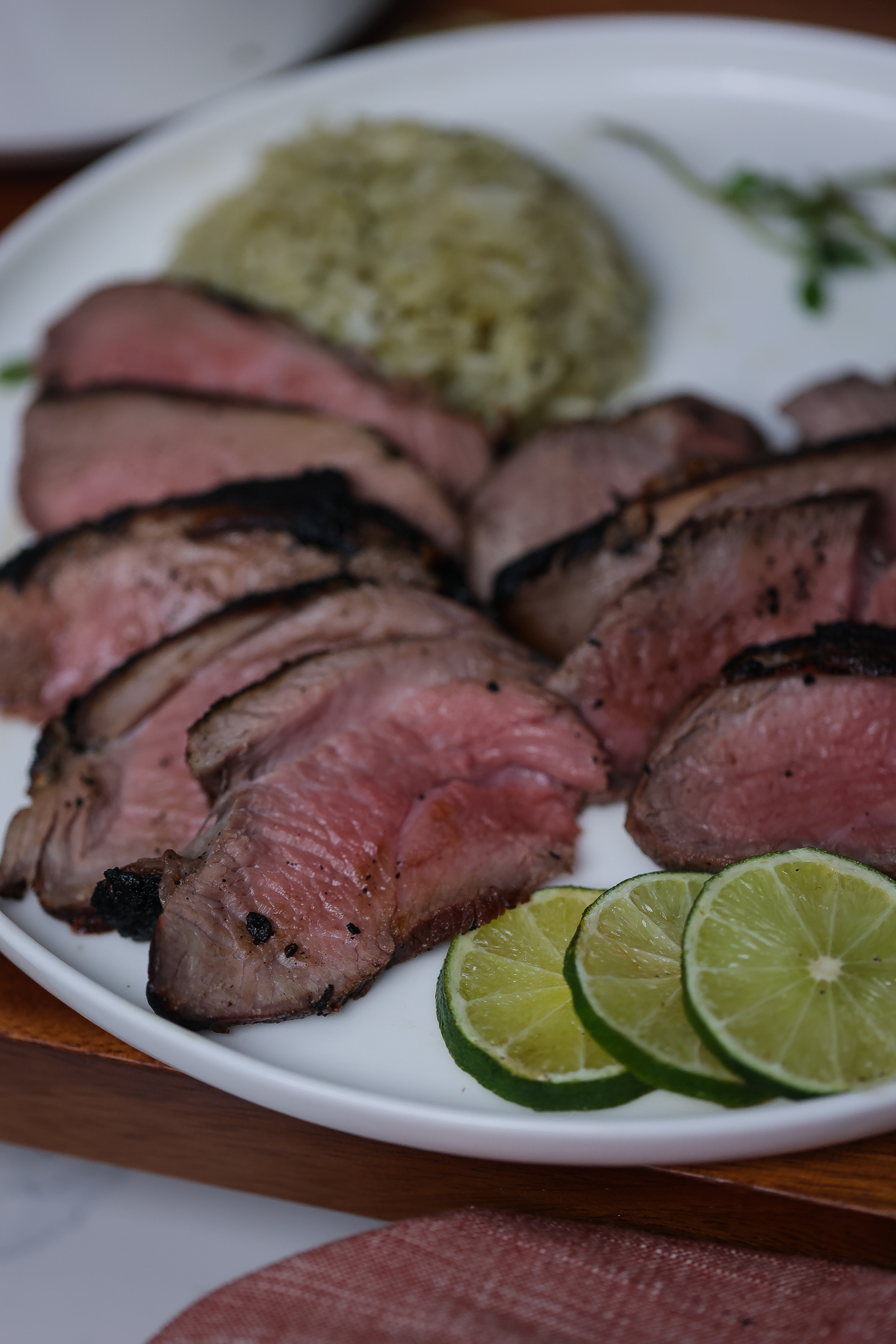 grilled butterflied leg of lamb on white plate