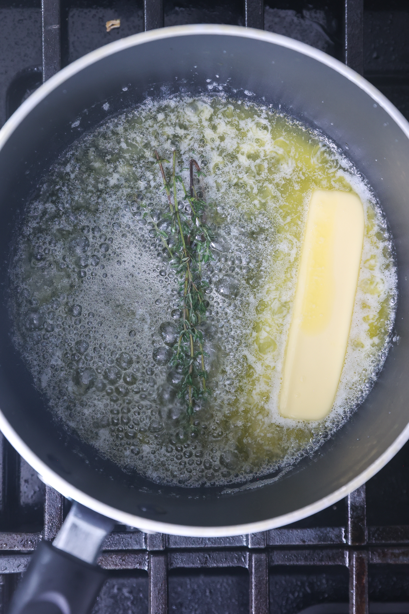 Fresh thyme being infused in butter.