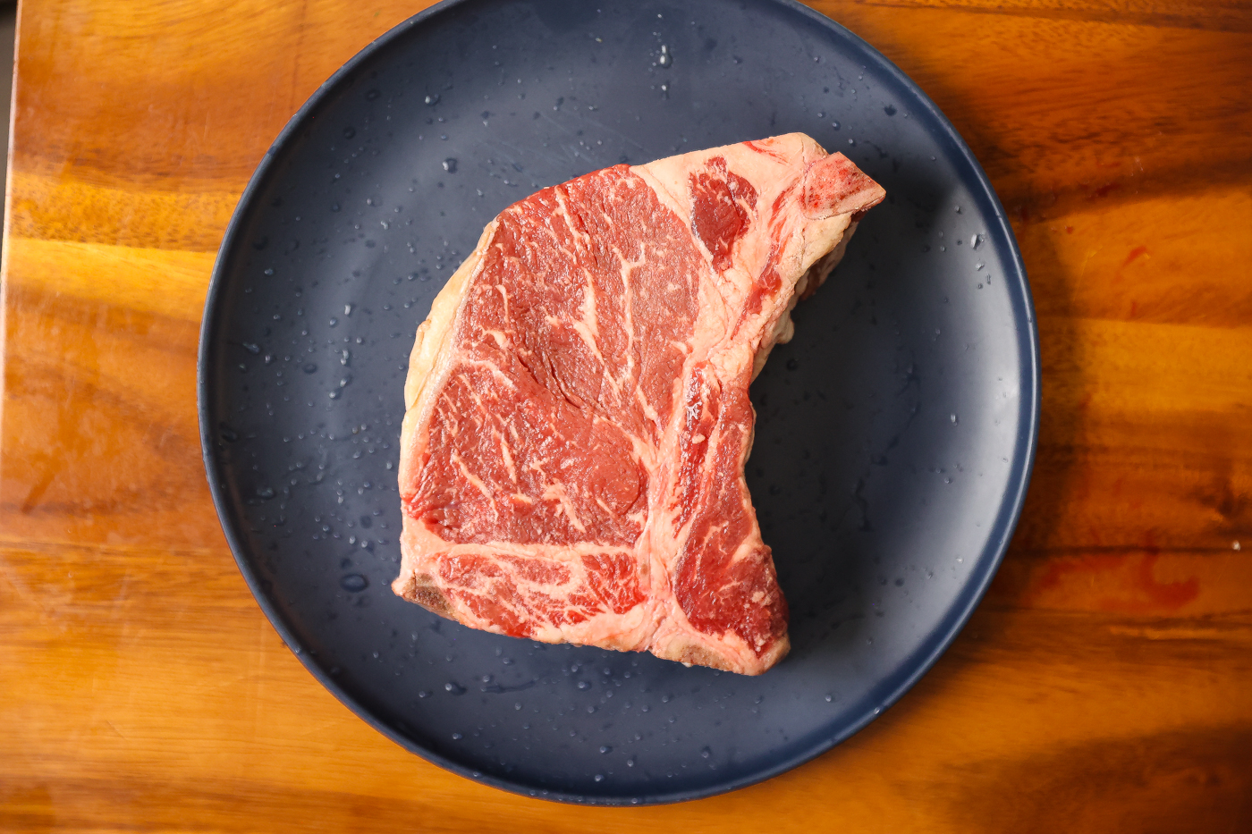 raw t-bone steak on plate