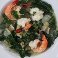 collard greens and spinach soup in a white bowl