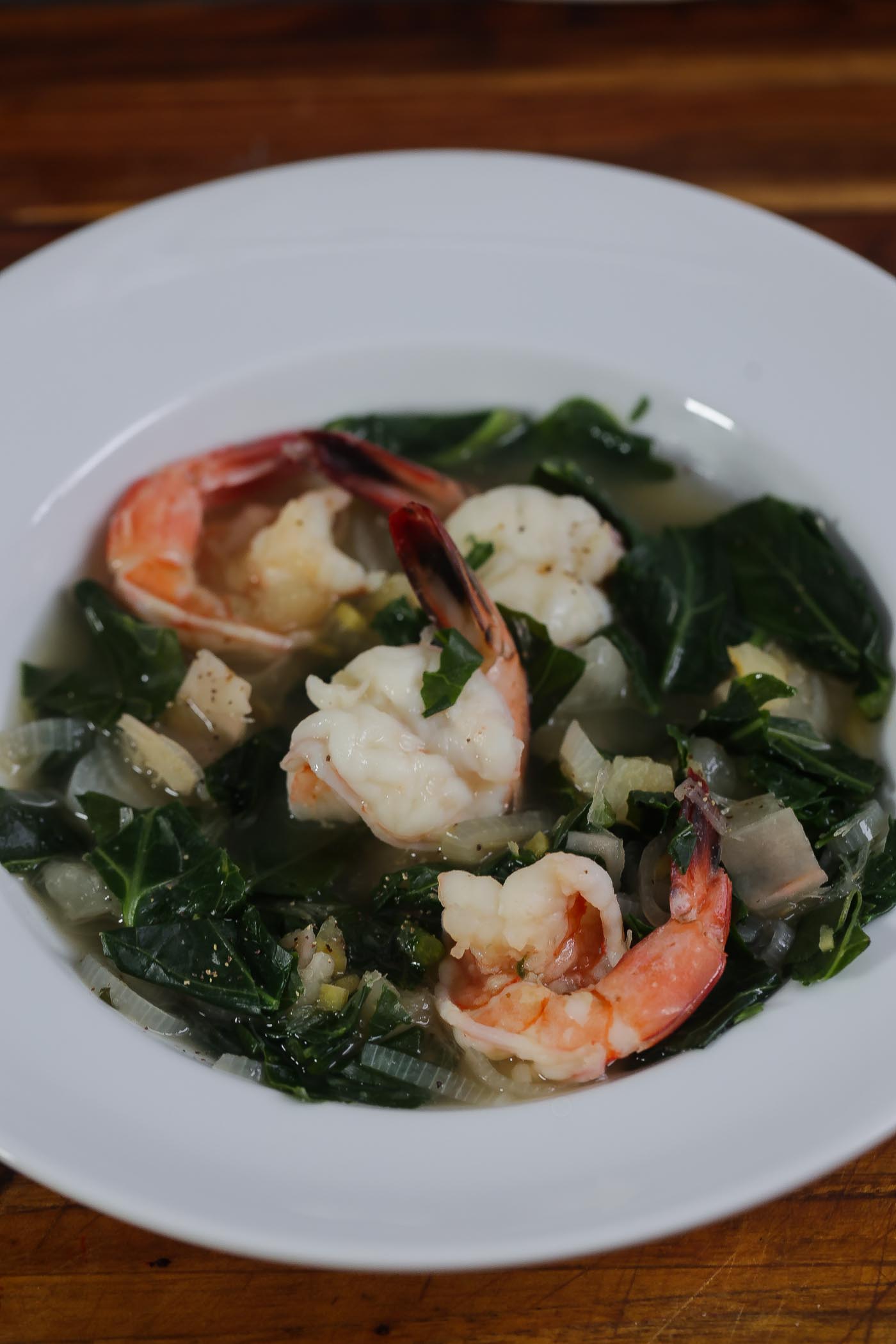 collard greens and spinach soup in a white bowl